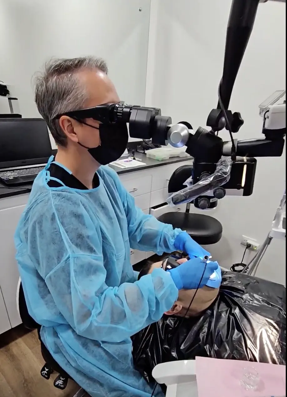 Dr. Camacho usando microscopio dental